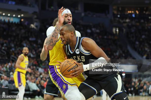 Khris Middleton of the Milwaukee Bucks is defended by Anthony Davis of the Los Angeles Lakers during a game at Fiserv Forum on March 26, 2024 in...