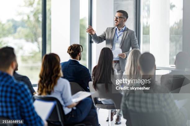heureux chef d’entreprise parlant à un groupe de ses collègues lors d’un séminaire dans la salle du conseil. - niveau de scolarisation photos et images de collection
