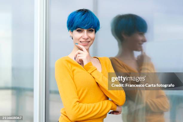 smiling young woman with short blue hair - blue nail polish stock pictures, royalty-free photos & images