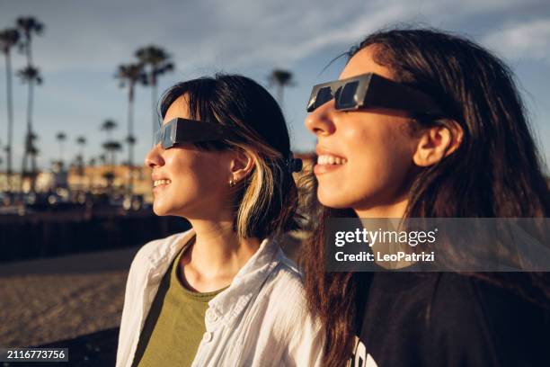 friends watching solar eclipse - eclipse imagens e fotografias de stock