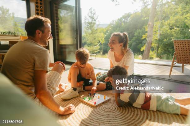 playing board games together - familie zuhause stock-fotos und bilder