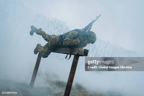 Recruit of the 1st Separate Mechanized Battalion ‘Da Vinci Wolves’ named after Dmytro Kotsiubailo overcomes an obstacle course while undergoing...
