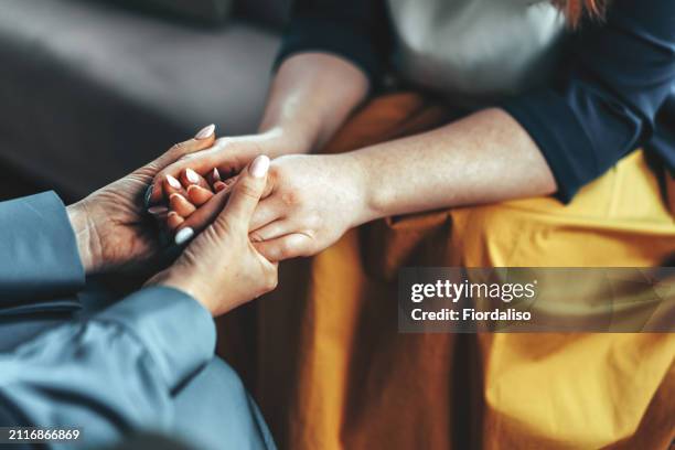 two women sitting in armchairs and talking. woman psychologist talking to patient - profesional de salud mental fotografías e imágenes de stock