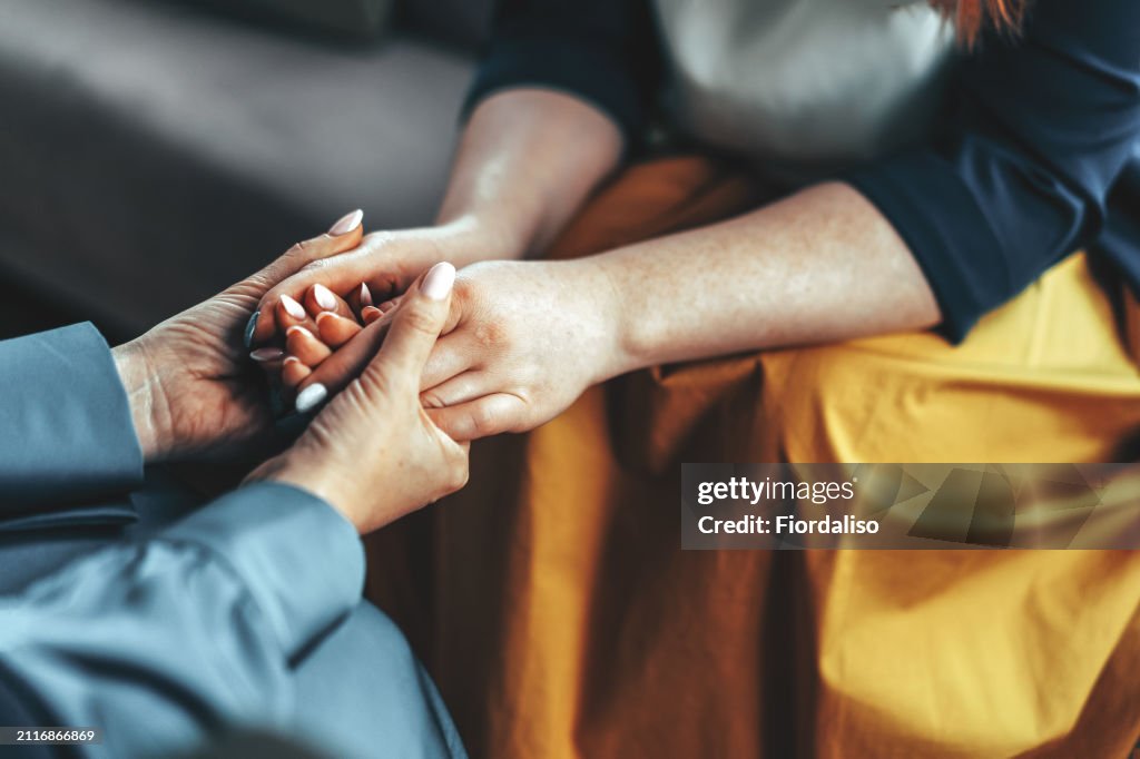 Two women sitting in armchairs and talking. Woman psychologist talking to patient