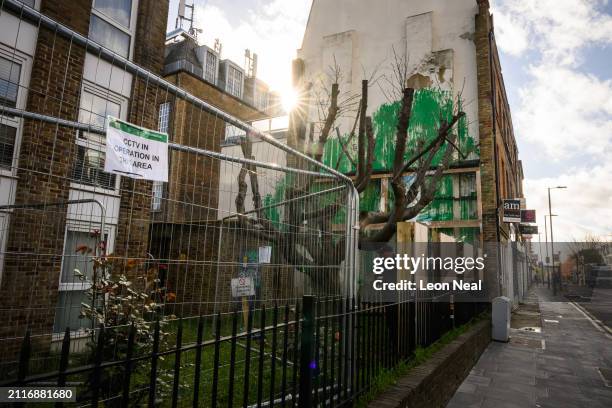 Security fencing, wooden hoardings and plastic screens surround the latest confirmed work by street artist Banksy, on March 27, 2024 in London,...