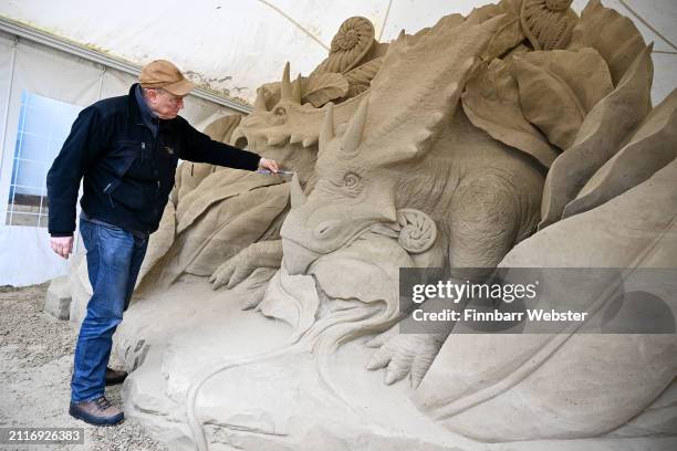 Preparing for the summer season opening this weekend, sculptor and director of Weymouth's SandWorld Sculpture Park, Mark Anderson tidies up a...