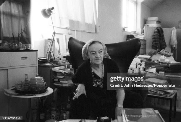 English artist and sculptor Barbara Hepworth seated in a chair in her studio workspace, Trwyn Studios in St Ives, Cornwall, England in 1970.