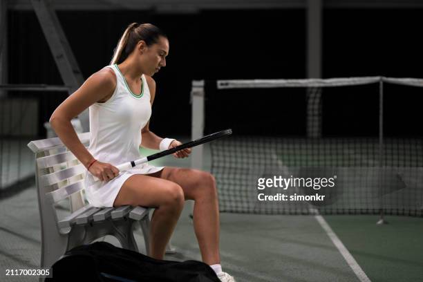 tennis player with racquet sitting on bench - tennis player stock pictures, royalty-free photos & images