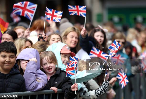 Well-wishers with Union Jack flags await the arrival of Queen Camilla during her visit to the Farmers' Market on March 27, 2024 in Shrewsbury,...