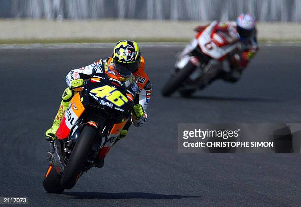 Italian driver Valentino Rossi with his honda followed by Japanese Makoto Tamada, takes a curve during the free practice of the Moto Grand Prix of...
