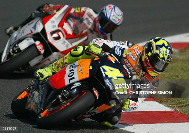 Italian driver Valentino Rossi with his honda followed by Japanese Makoto Tamada, takes a curve during the free practice of the Moto Grand Prix of...