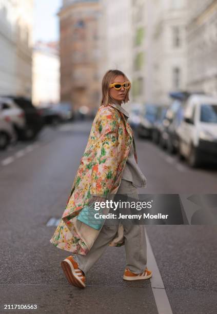 Karin Teigl seen wearing Loewe yellow sunglasses, Agolde light grey denim straight leg pants, Stine Goya yellow with colorful flower embroidered...