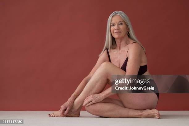 full length view of senior woman in maroon undergarments - hoop earring stock pictures, royalty-free photos & images