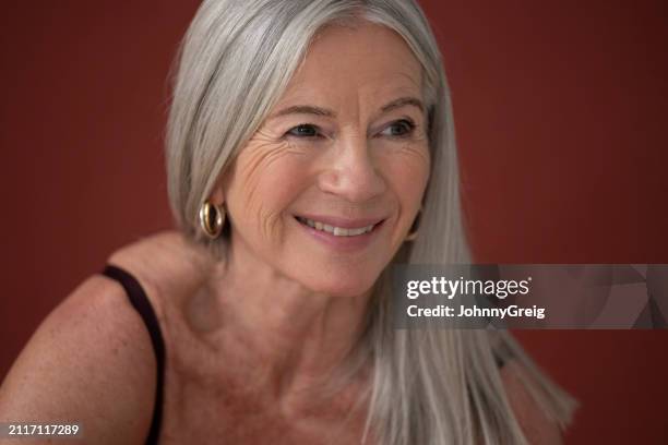 candid studio portrait of senior woman in semi-dress - hoop earring stock pictures, royalty-free photos & images