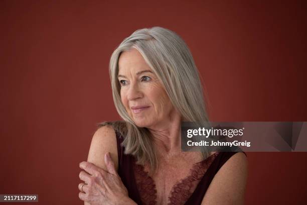 mujer mayor en deslizamiento contra fondo de color rosa - una sola mujer mayor fotografías e imágenes de stock