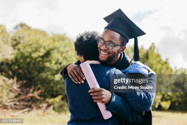 young male graduate hugging mother on graduation day, smiling proudly at campus grounds - um dia na vida de imagens e fotografias de stock