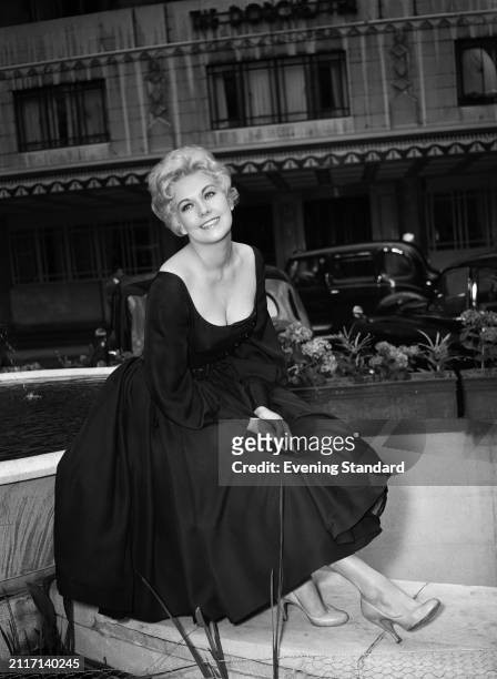 Actress Kim Novak sitting in front of The Dorchester hotel, London, May 25th 1956.