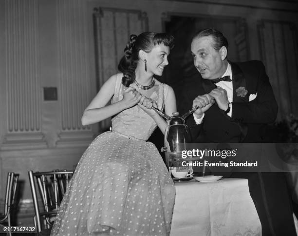 Actress Janette Scott and producer Mario Zampi operating a coffee machine, February 5th 1955.