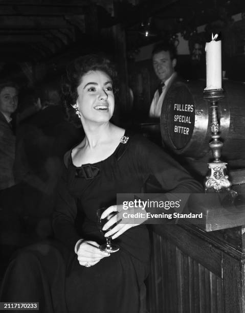 Actress Lynne Cole sitting beside a pub bar, January 6th 1955.