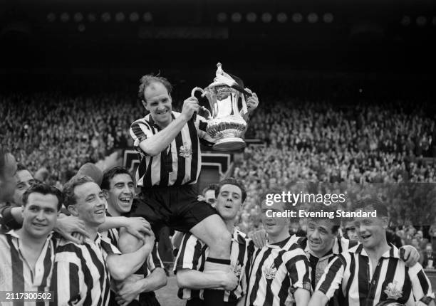 Newcastle United Football Club captain Jimmy Scoular holds up the FA Cup while carried on his teammates' shoulders, Wembley Stadium, London, May 7th...