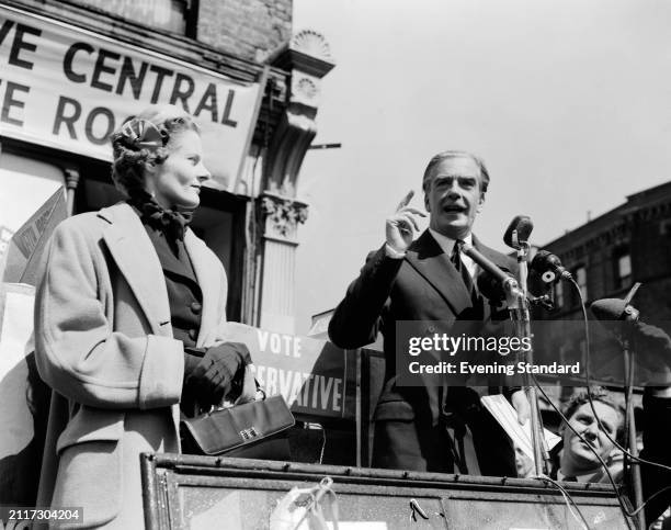 Prime Minister Sir Anthony Eden speaking on a podium in the street outside the Conservative Central Committee Room with his wife Clarissa Eden...