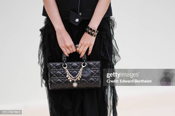 Black quilted leather bag is seen with a bracelet, outside Dior, during the Womenswear Fall/Winter 2024/2025 as part of Paris Fashion Week on...