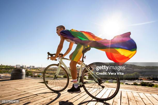 full length view of homosexual man riding a bicycle in the park - justice sociale concept photos et images de collection