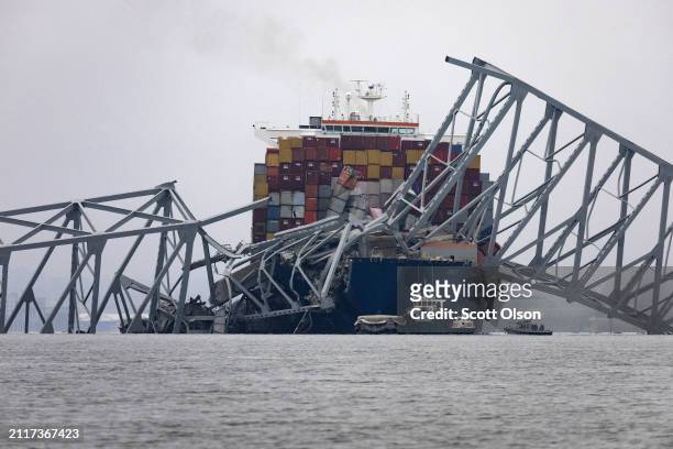Workers continue to investigate and search for victims at the scene after the cargo ship Dali collided with the Francis Scott Key Bridge yesterday...