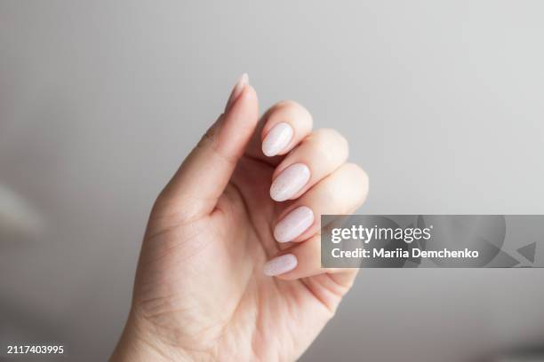 hand with beautiful manicure - pink gel nails with glitter - pink nail polish stock pictures, royalty-free photos & images