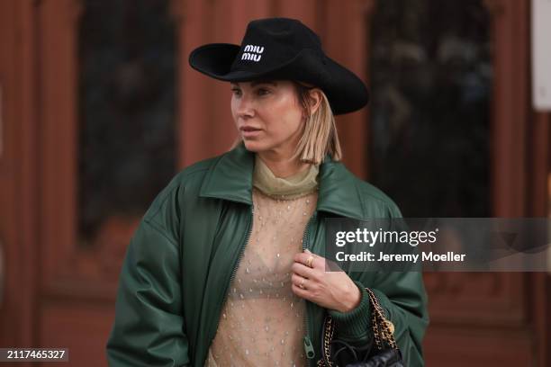 Karin Teigl seen wearing Miu Miu black cowboy hat, Zara beige transparent crystal high neck top, Zara dark green puffer bomber jacket and Bulgari...