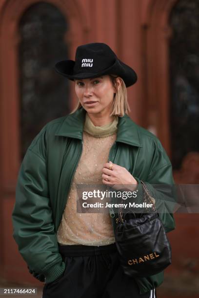 Karin Teigl seen wearing Miu Miu black cowboy hat, Zara beige transparent crystal high neck top, Zara dark green puffer bomber jacket, Adidas black...