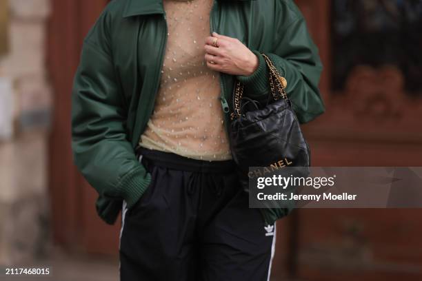 Karin Teigl seen wearing Zara beige transparent crystal high neck top, Zara dark green puffer bomber jacket, Adidas black wide leg track pants,...