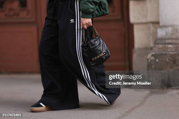 Karin Teigl seen wearing Zara dark green puffer bomber jacket, Adidas black wide leg track pants, Chanel black leather 22 mini bag, Bulgari Bzero...