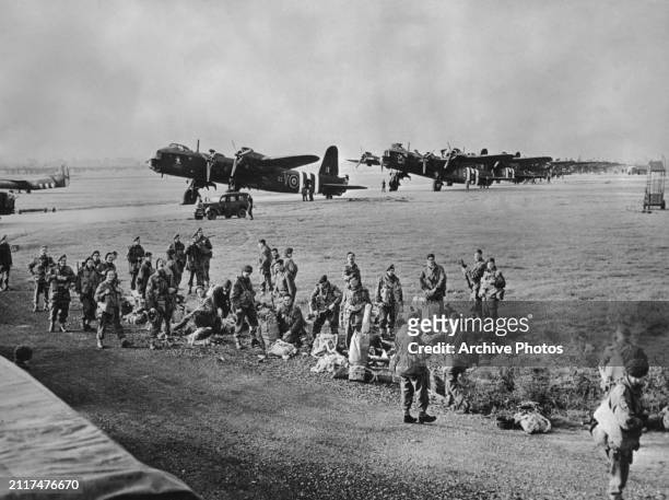 Paratroops from 3rd Platoon, 21st Independent Parachute Company, British 1st Airborne Division prepare their parachutes and equipment before...