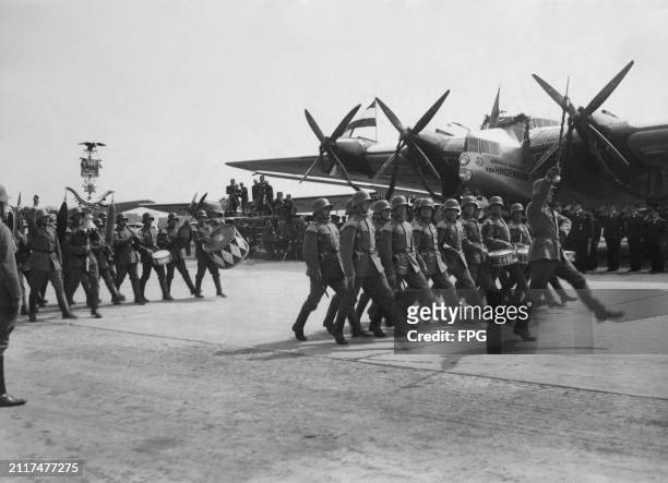 Marching band of the German Army parades past the Lufthansa Junkers G38 four-engined passenger aircraft registration D-APIS during a ceremony to name...