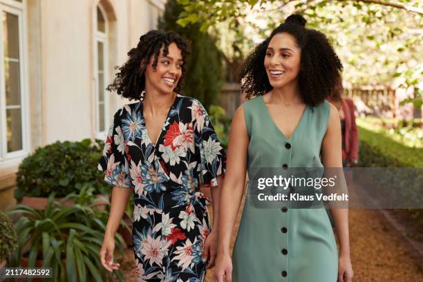 happy women walking together at party - black dress stock pictures, royalty-free photos & images