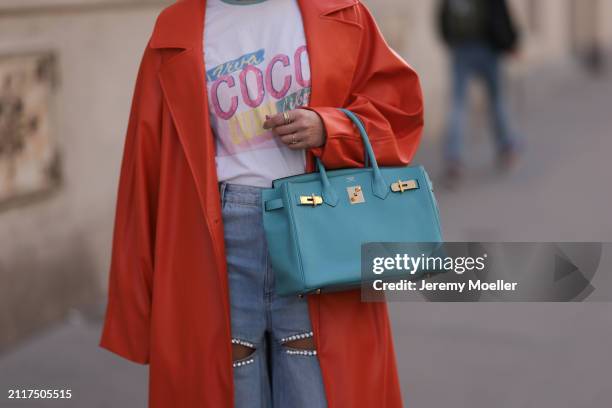 Karin Teigl seen wearing Chanel Coco white with colorful logo print cotton t-shirt, Aera light blue rhinestones pattern cut-outs wide leg jeans /...