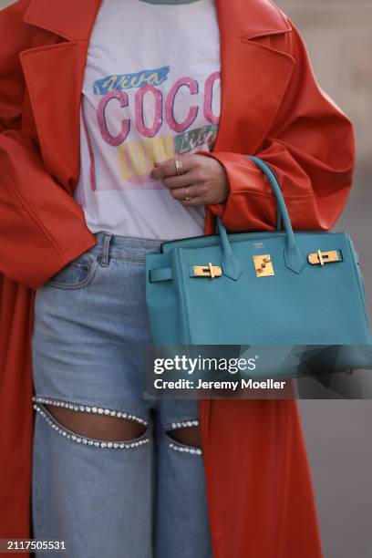 Karin Teigl seen wearing Chanel Coco white with colorful logo print cotton t-shirt, Aera light blue rhinestones pattern cut-outs wide leg jeans /...