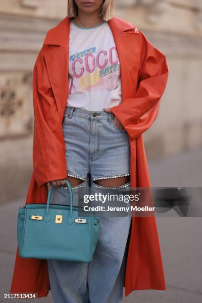 Karin Teigl seen wearing Chanel Coco white with colorful logo print cotton t-shirt, Aera light blue rhinestones pattern cut-outs wide leg jeans /...