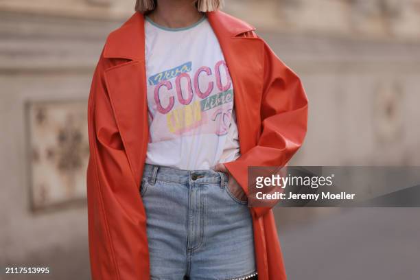 Karin Teigl seen wearing Chanel Coco white with colorful logo print cotton t-shirt, Aera light blue rhinestones pattern cut-outs wide leg jeans /...