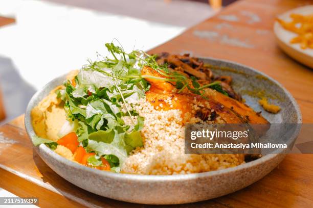 a plate with salad and quinoa on a wooden table - quinoa stock pictures, royalty-free photos & images