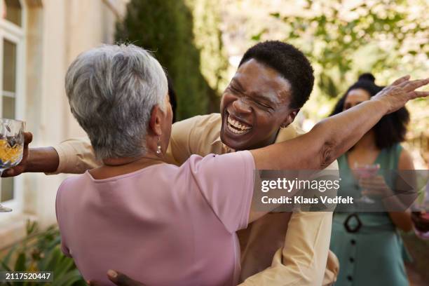 cheerful young man greeting senior woman - affectionate stock pictures, royalty-free photos & images