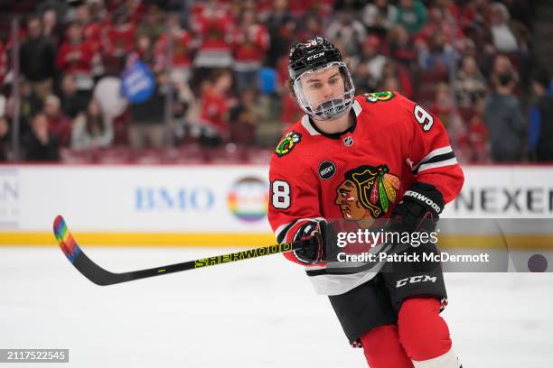 Connor Bedard of the Chicago Blackhawks warms up with pride tape on his stick before a game against the Calgary Flames at the United Center on March...