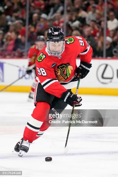 Connor Bedard of the Chicago Blackhawks skates with the puck during the second period against the Calgary Flames at the United Center on March 26,...