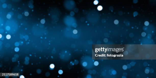 blue defocused lights over dark background - confeti fotografías e imágenes de stock
