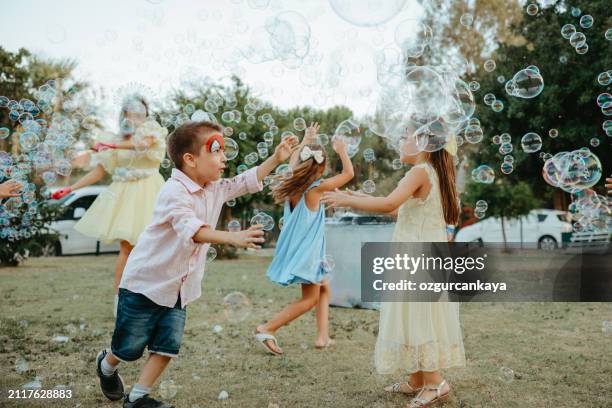 glückliche kleine mädchen mit schaum auf dem kopf, in nassen klamotten auf einer schaumparty oder im urlaub an einem sonnigen, heißen sommertag - kindergeburtstag stock-fotos und bilder