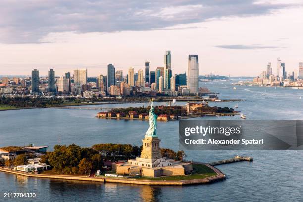 statue of liberty and jersey city skyline seen from helicopter, new york city, usa - staat new york stockfoto's en -beelden