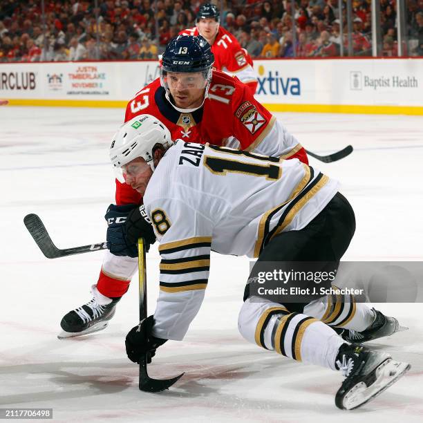 Sam Reinhart of the Florida Panthers tangles with Pavel Zacha of the Boston Bruins during a face off at the Amerant Bank Arena on March 26, 2024 in...