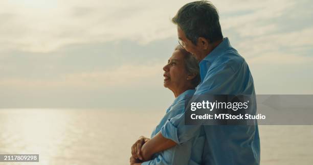asian elderly cheerful couple smiling happily while embracing on beach enjoying the sea view. a happy senior adult people enjoy the travel lifestyle after retirement. - mes stock pictures, royalty-free photos & images