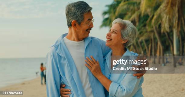 asian elderly cheerful couple smiling happily while embracing and looking at camera on beach enjoying the sea view. a happy senior adult people enjoy the travel lifestyle after retirement. - mes stock pictures, royalty-free photos & images